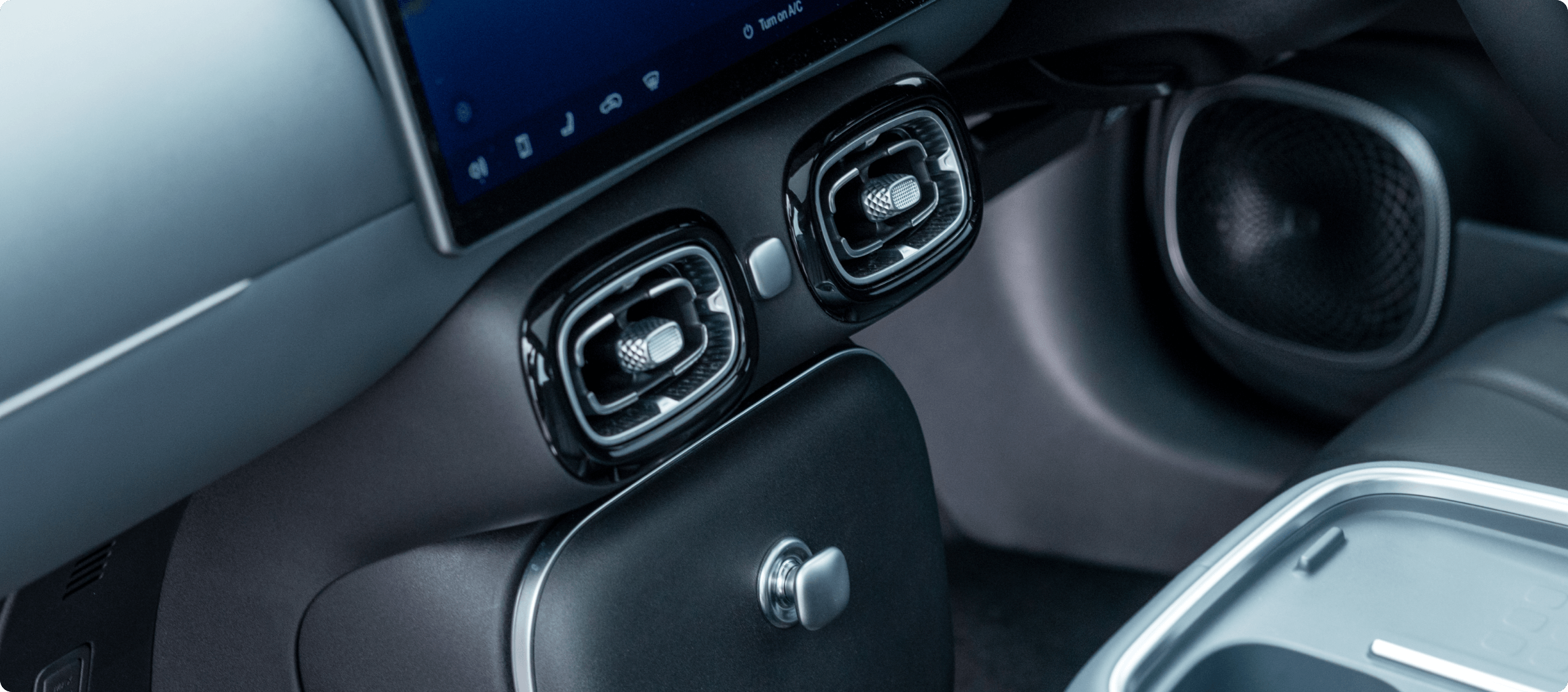 Close-up of the AION UT interior showing central air vents and climate control area