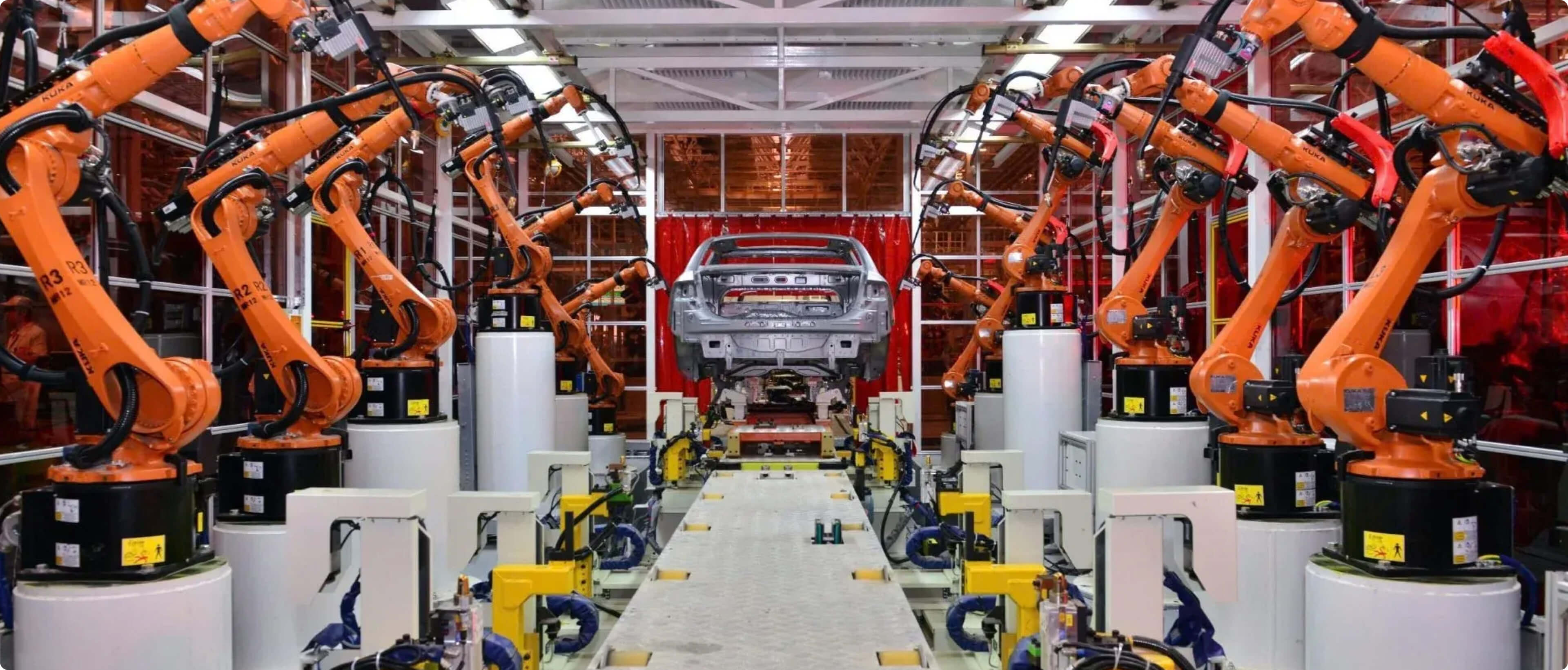 Automated car manufacturing line with robotic arms assembling a vehicle body