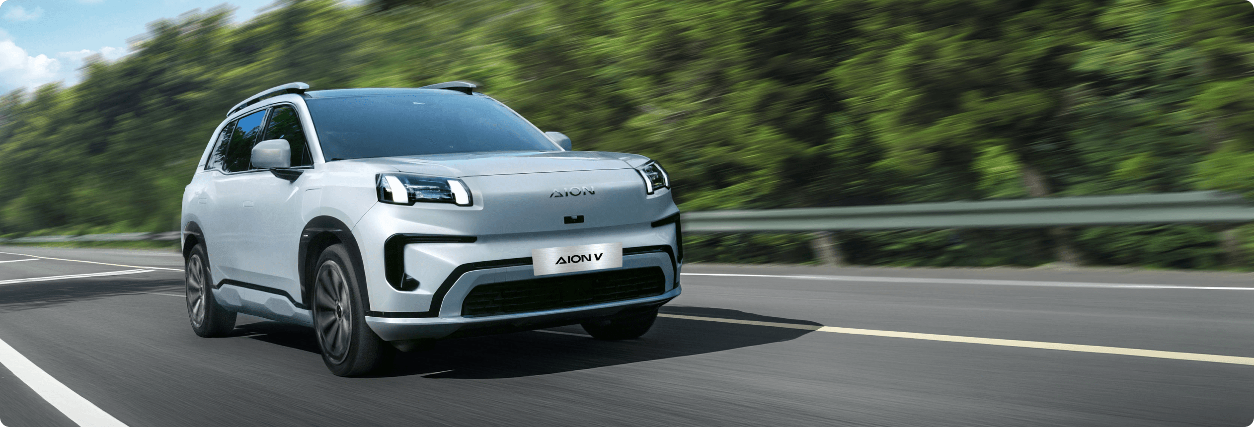 AION V driving on a highway with trees blurred in the background