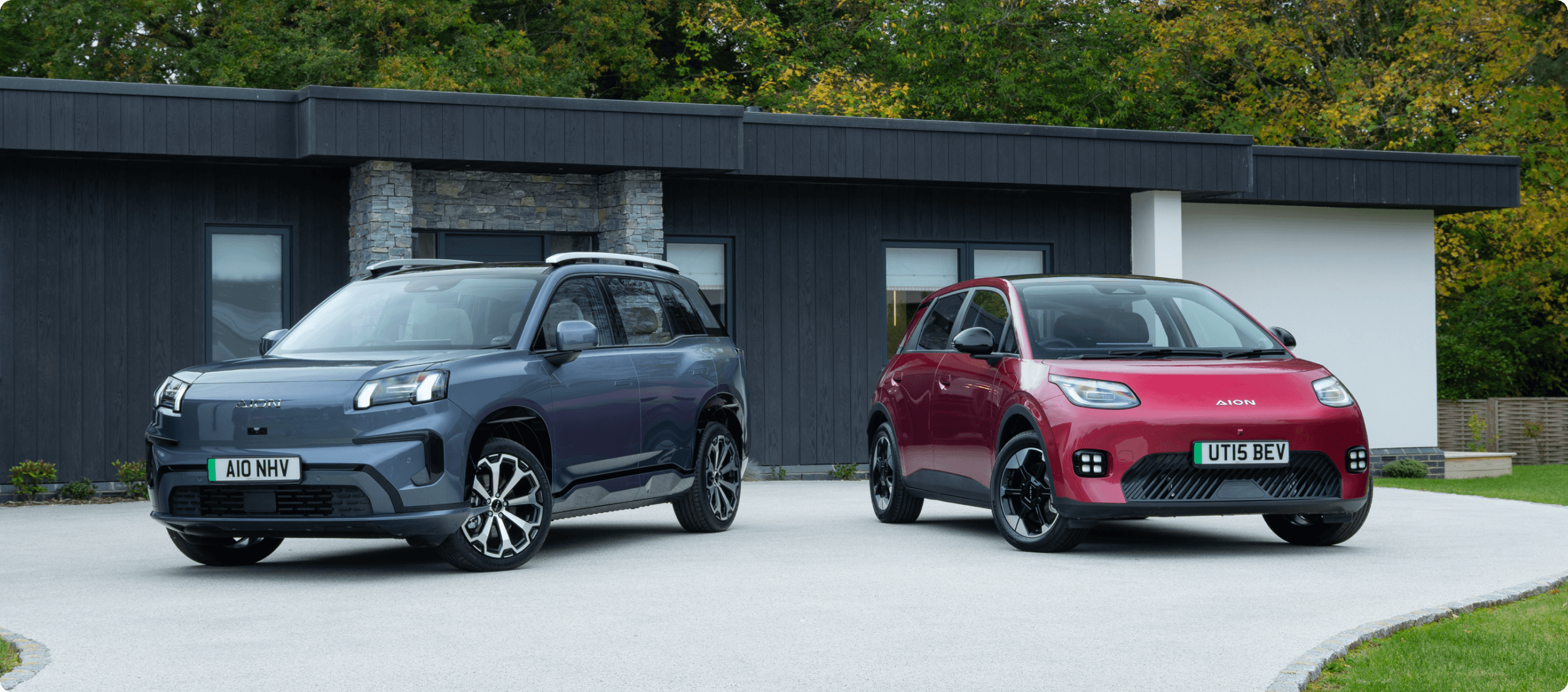 Two AION cars parked outside a modern home