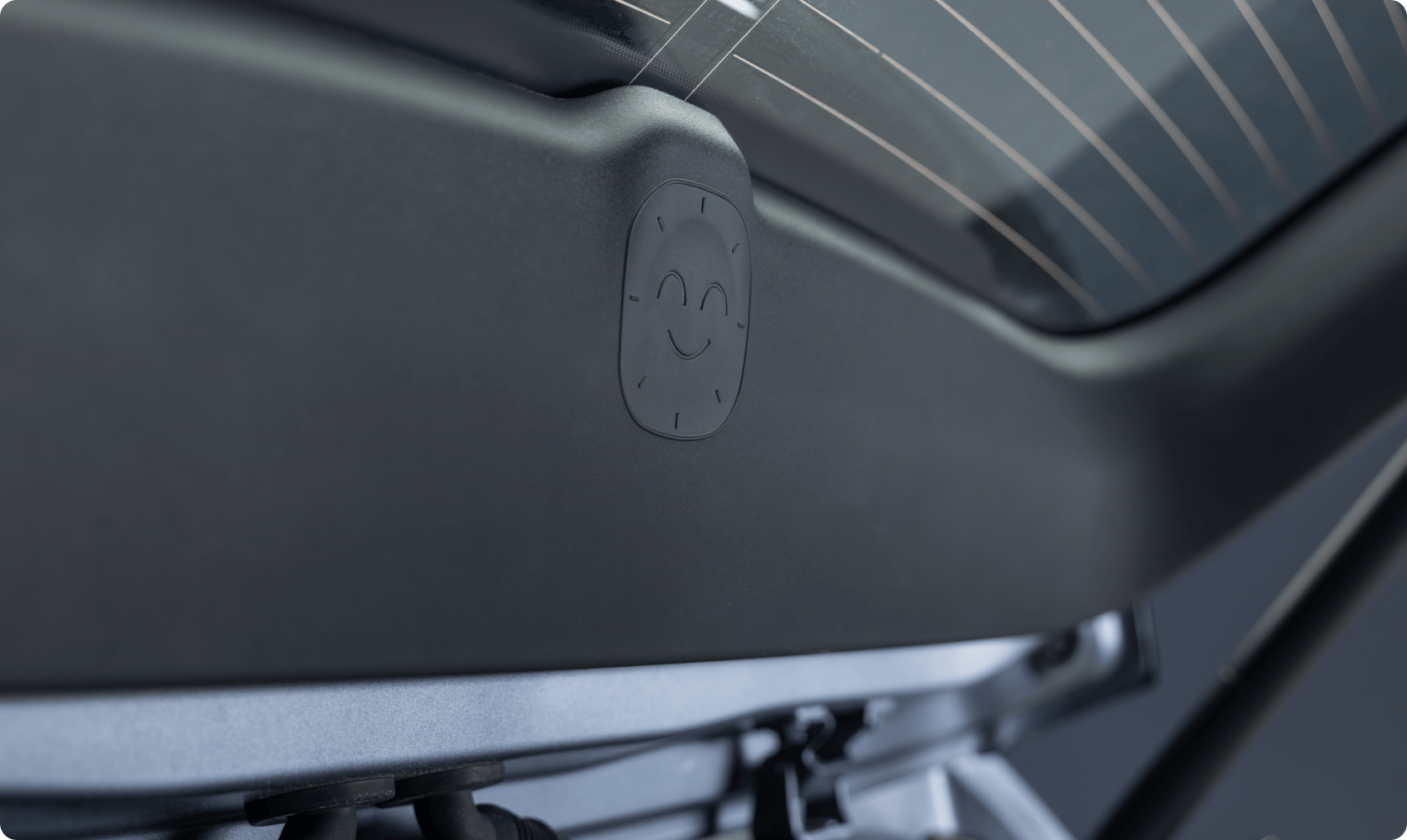 Close-up of a small embossed smiley face detail on the AION vehicle interior panel