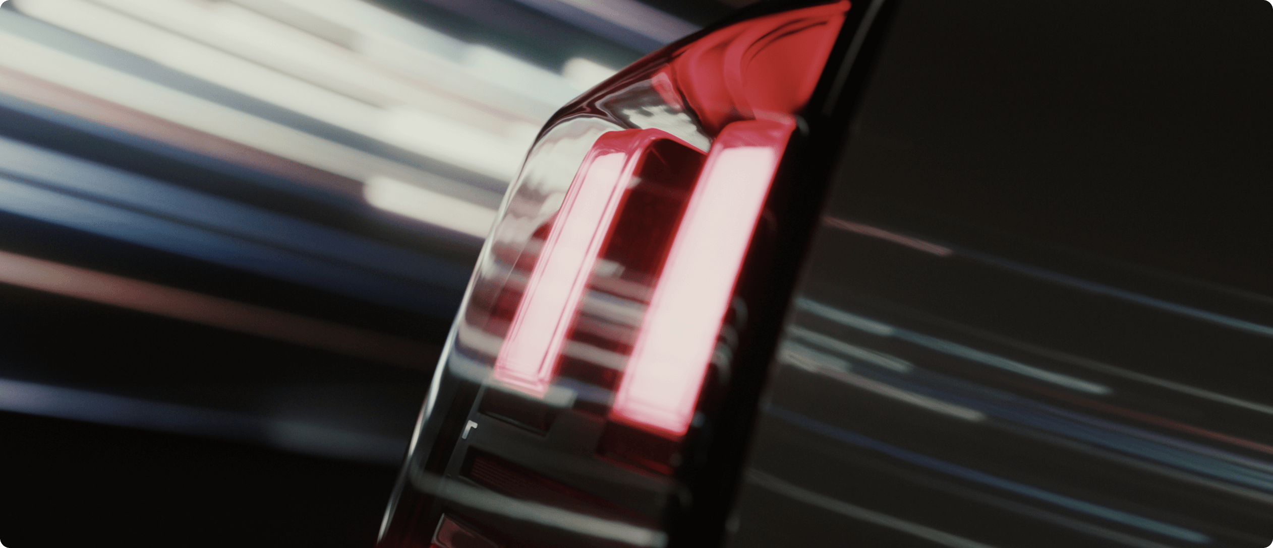 Close-up of AION V rear LED tail light illuminated, with motion blur in the background