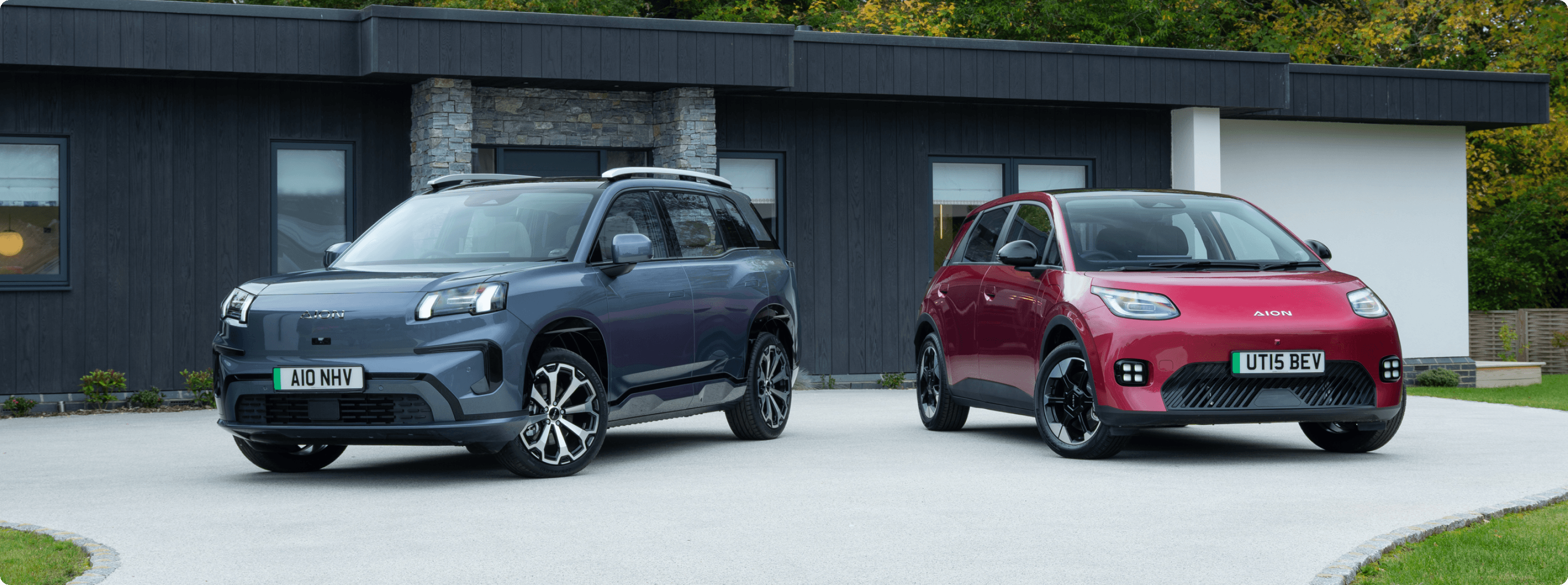 Grey AION V and red AION UT parked outside a modern house