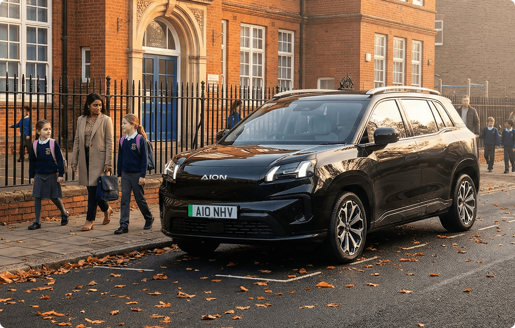 AION V parked outside a school as a woman walks with two children in school uniforms along the pavement