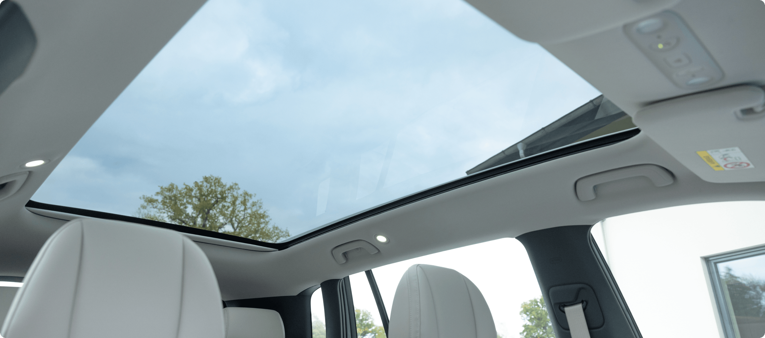 Large panoramic glass roof inside an AION V, viewed from the front seats