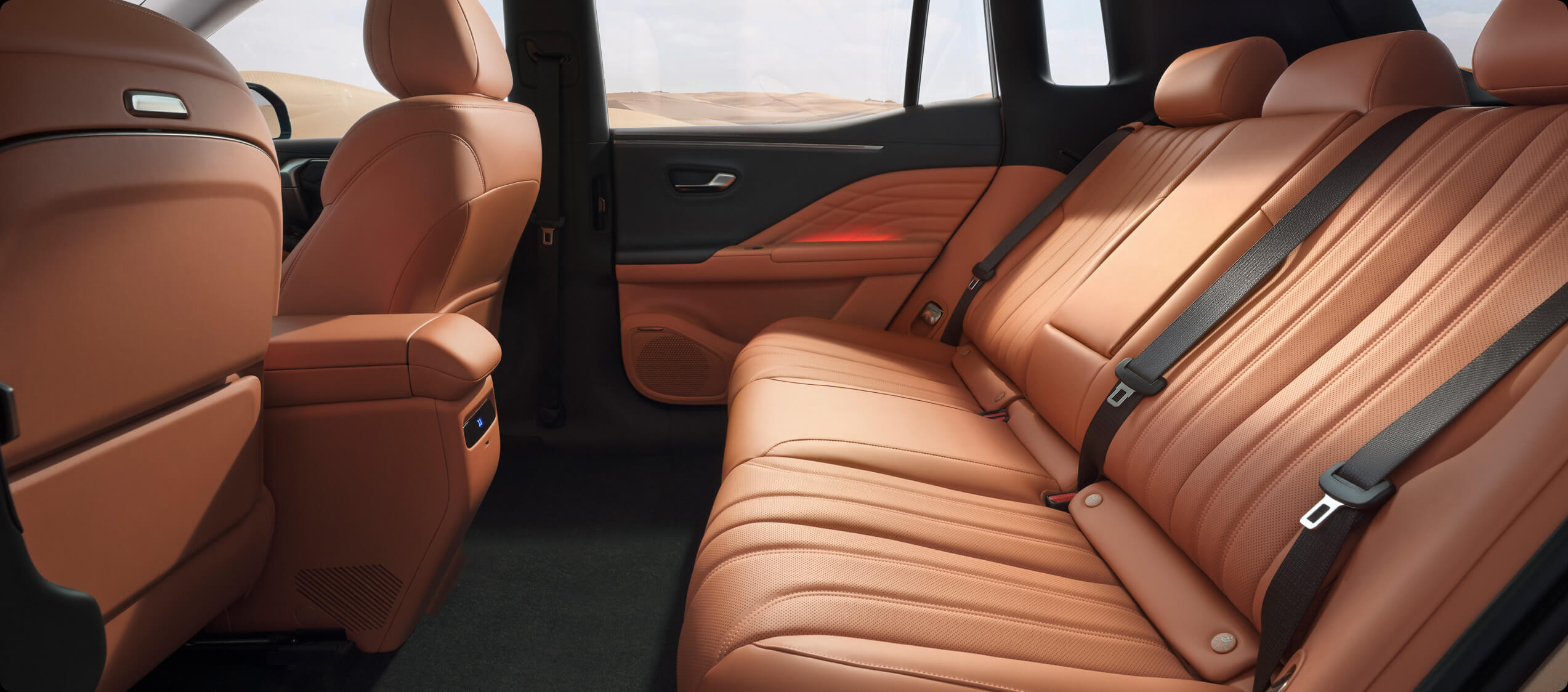Spacious rear passenger area of the AION V with orange upholstery and three rear seats